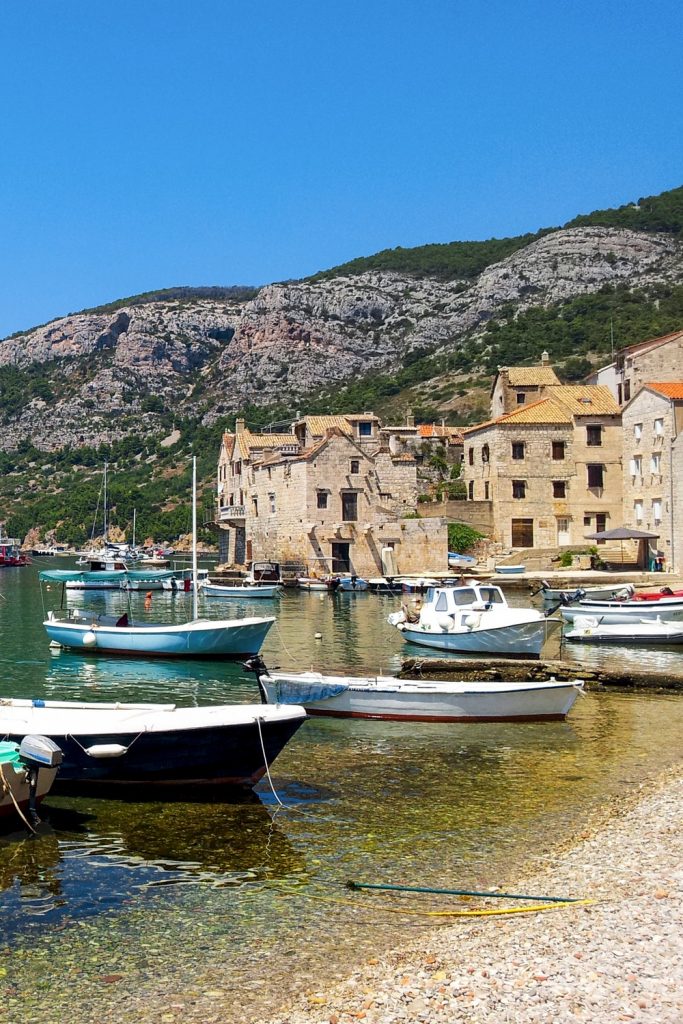 Boats moored in bay of Beautiful old island town of Komiža on Vis island in Croatia.